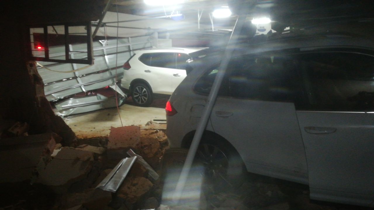 Driver injured after driving through garage wall