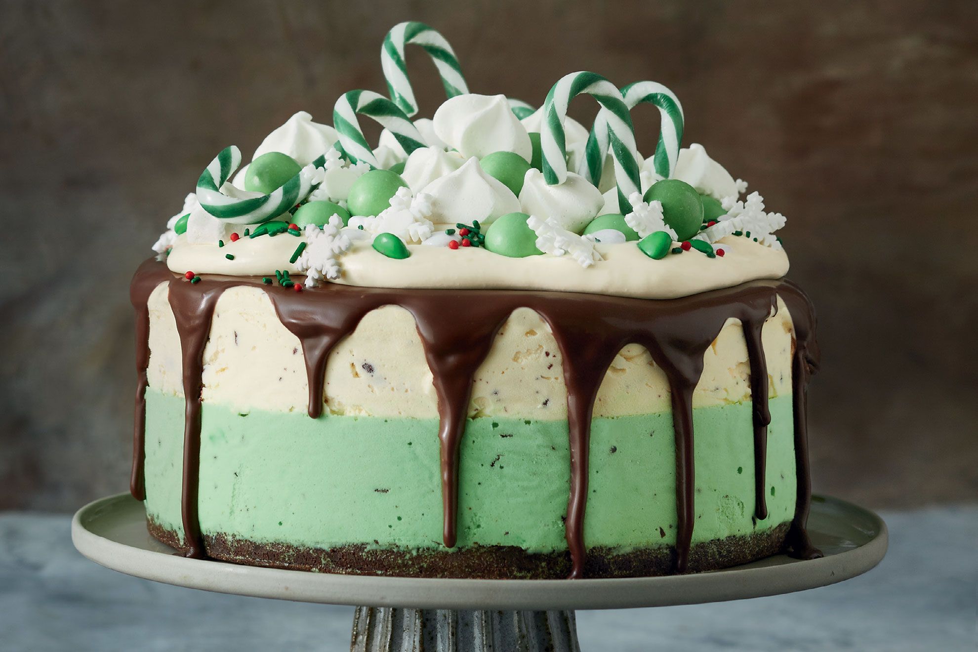 Layers of vanilla and peppermint ice cream (dotted with crushed choc mint balls) are covered in melted chocolate and topped with the striking green Darrell Lea Minty Crunchy Chocolate Balls. 8 Ingredients - 2 x 185g pkts Darrell Lea Minty Crunchy Chocolate Balls - 2L vanilla ice-cream - Green liquid food colouring, to tint - 1 tsp peppermint extract - 125g Choc Ripple biscuits - 40g butter, melted - 100g Darrell Lea dark chocolate, chopped - 2 tbsp thickened cream 6 Method / Steps Step 1 Grease a 7.5cm-deep, 8.5 x 17.5cm (base measurement) loaf pan. Line base and sides with baking paper, extending paper 2cm above the edge of the pan. Place one packet of the chocolate balls in a sealable plastic bag. Use a rolling pin to pound and finely crush. Step 2 Place half of the ice cream in a large bowl. Set aside, at room temperature, for 10 minutes to soften slightly. Add half the crushed chocolate balls. Use a spatula to fold together until well combined. Spoon the ice-cream mixture over the base of the prepared pan. Smooth the surface. Place in the freezer for at least 30 minutes or until required. Step 3 Place remaining ice cream in a large bowl. Set aside, at room temperature, for 10 minutes to soften slightly. Add a few drops of green food colouring, a few drops of peppermint extract, and the remaining crushed chocolate balls. Use a spatula to fold together until well combined. Spoon mixture over vanilla ice-cream layer. Smooth the surface. Place in the freezer for at least 30 minutes or until required. Step 4 Place biscuits in a food processor and process until finely chopped. Add butter. Process until well combined. Press mixture over top of green ice-cream layer. Freeze for 6 hours or overnight until set. Step 5 Place dark chocolate and cream in a microwave-safe bowl. Microwave on High, stirring halfway through, for 1 minute or until melted and smooth. Set aside for 15 minutes to cool slightly. Step 6 Turn cake onto a serving plate. Spoon chocolate mixture over the cake, allowing it to drip down the long sides (see note). Decorate with rows of remaining whole chocolate balls. Serve immediately. source - cooking365coza